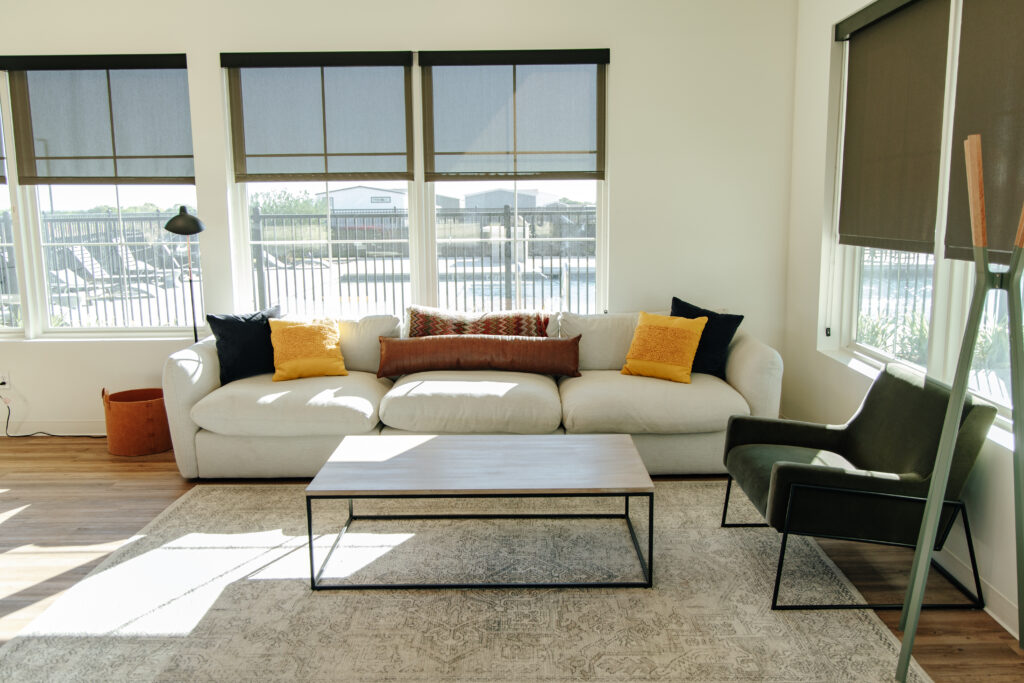 Clubhouse lounge with sectional sofa and large windows at Higdon Oaks